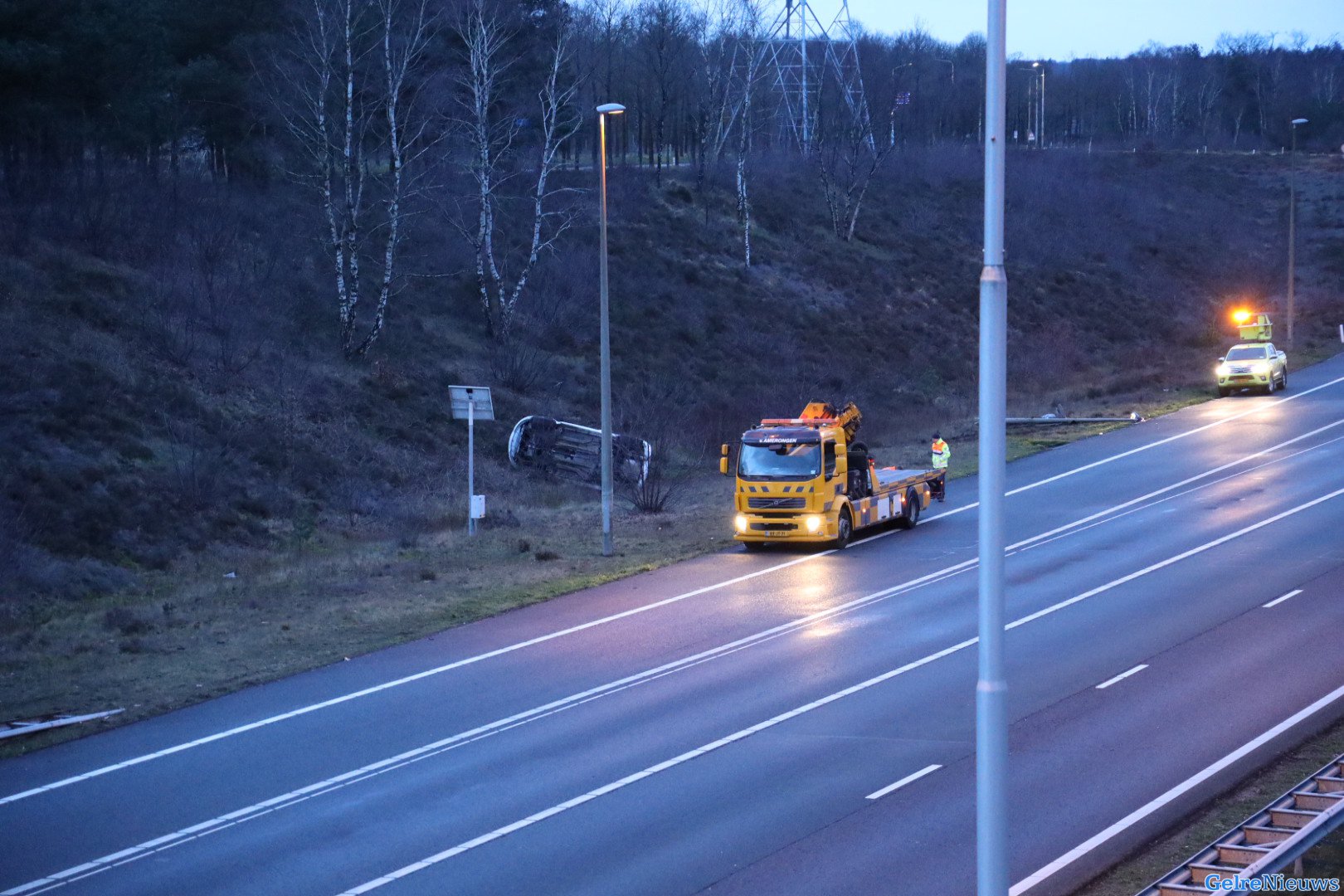 Auto ramt lantaarnpaal en belandt op dak in berm langs A50