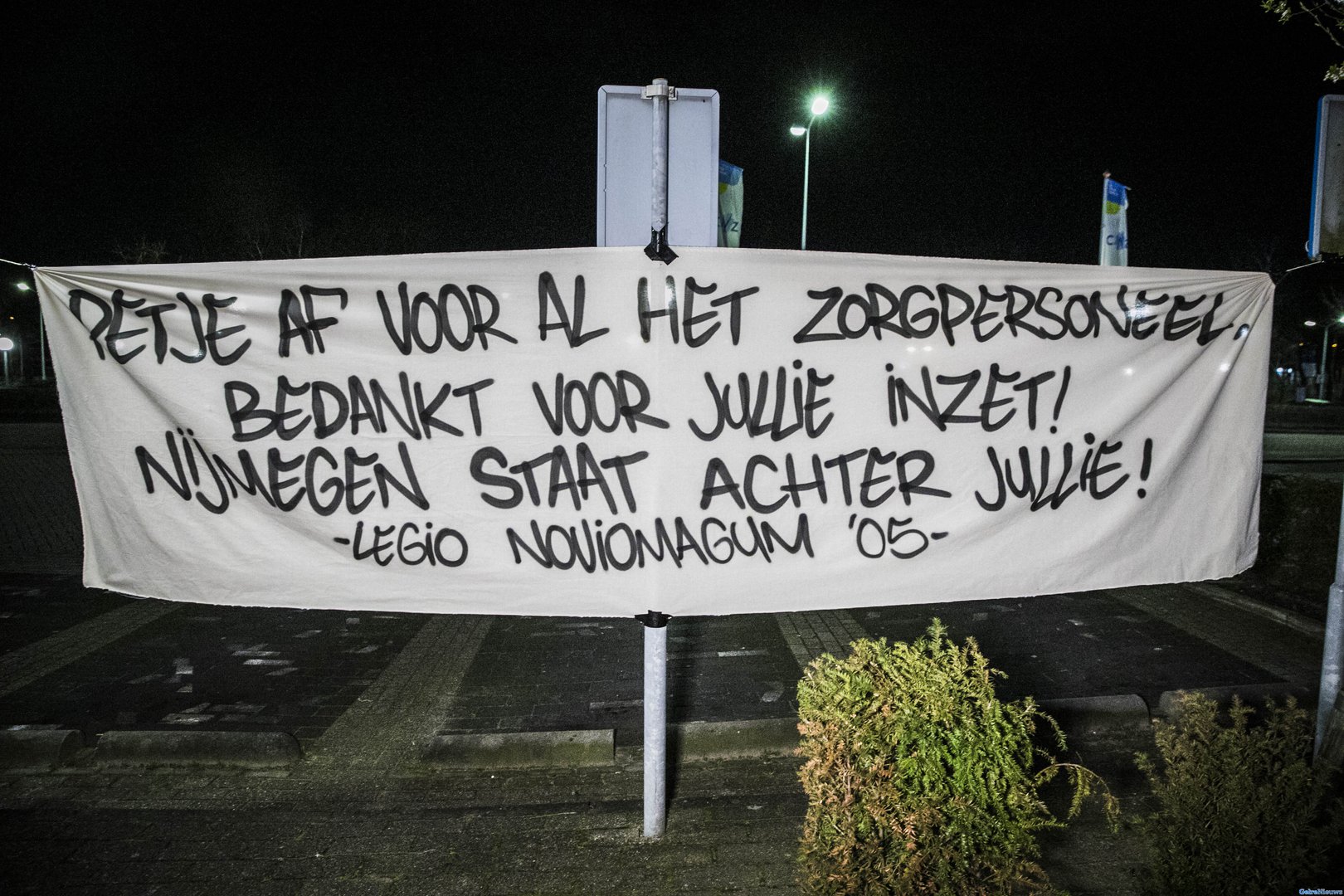 NEC supporters hangen steunbetuiging op bij ziekenhuis