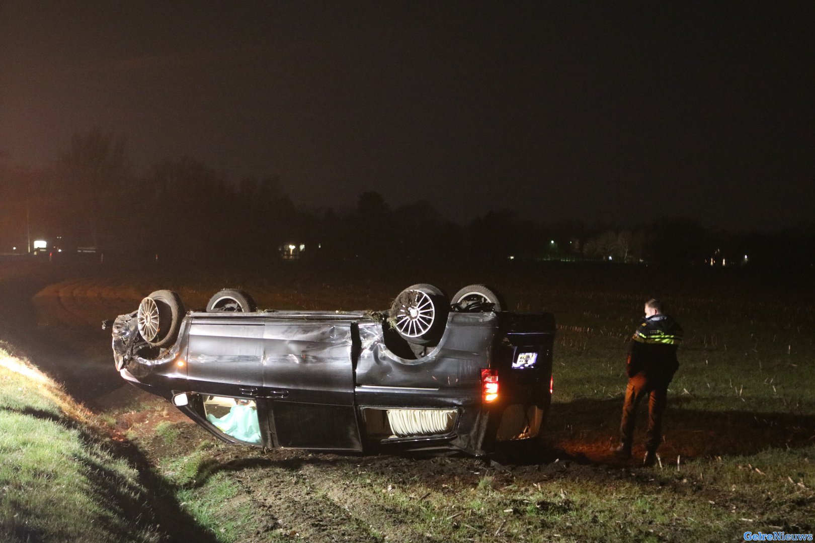 Rouwauto slaat over de kop en belandt in weiland