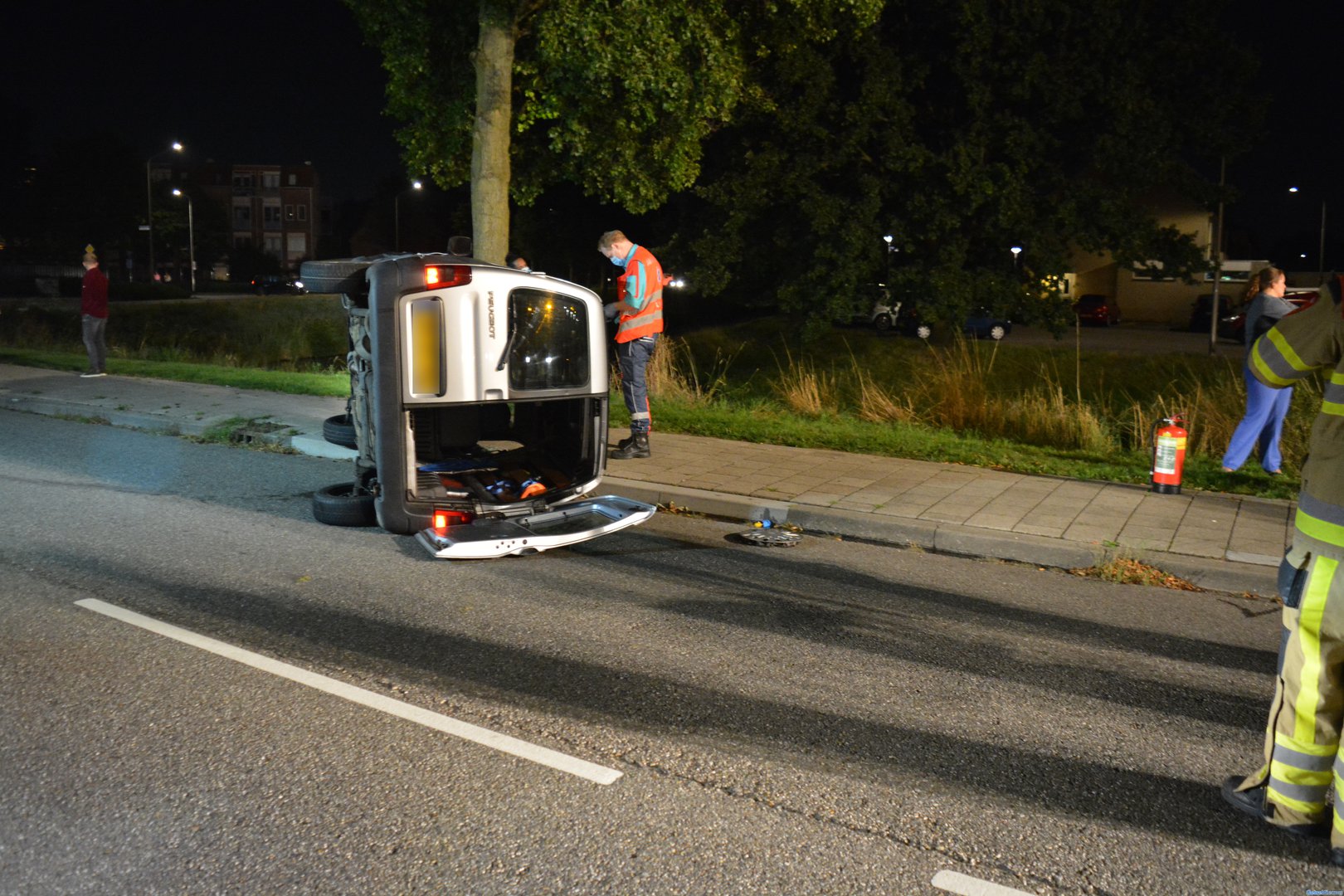 Bestelbus op zijnkant: inzittenden slaan op de vlucht