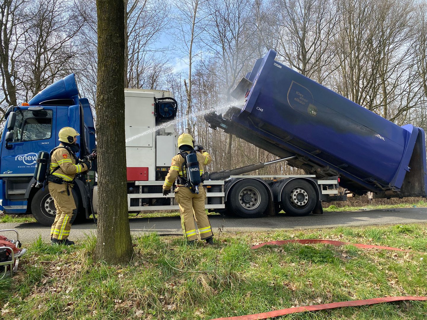 Brandweer blust brandende vuilniswagen geladen met papier