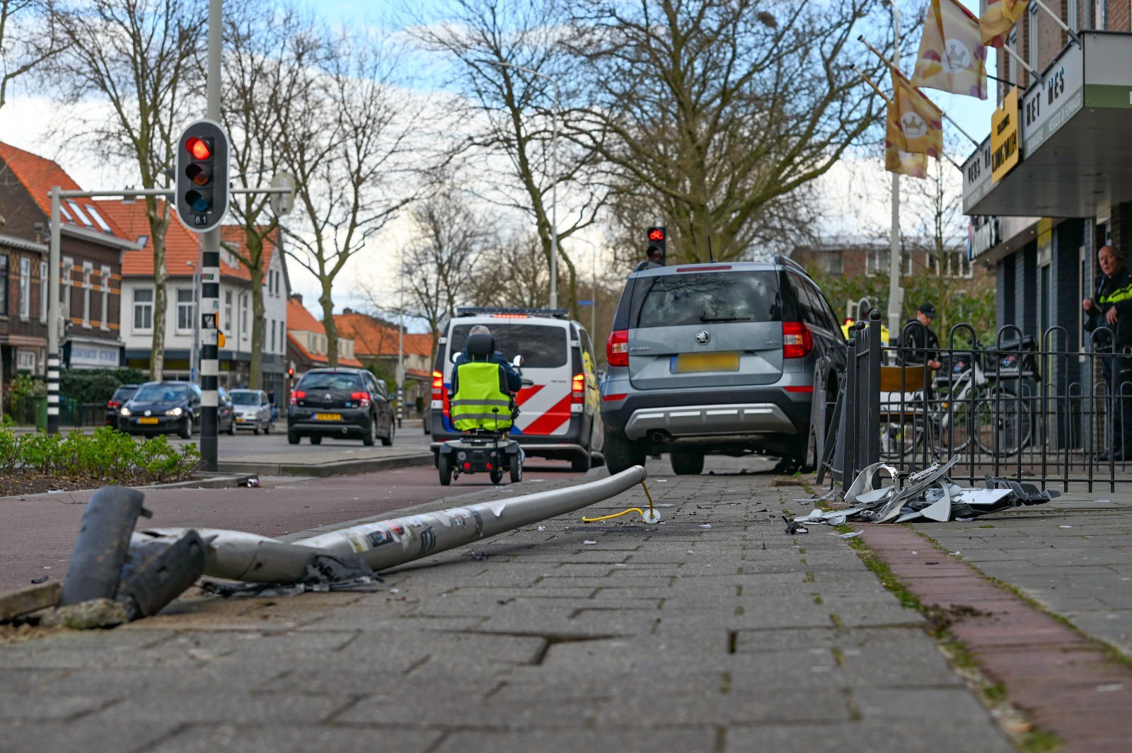 Automobiliste raakt van de weg, ramt lantaarnpaal en een hekwerk