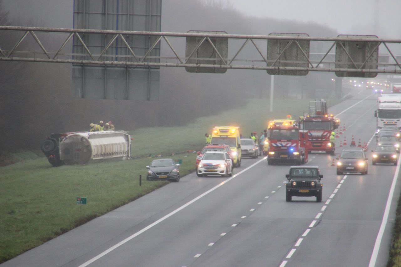 Vrachtwagen met veevoer omgekanteld, naast de A1 beland