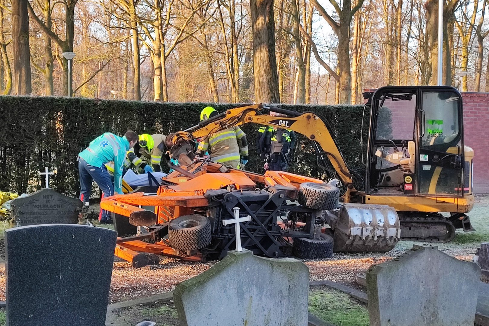 Man slaat om met graafmachine op begraafplaats en raakt bekneld