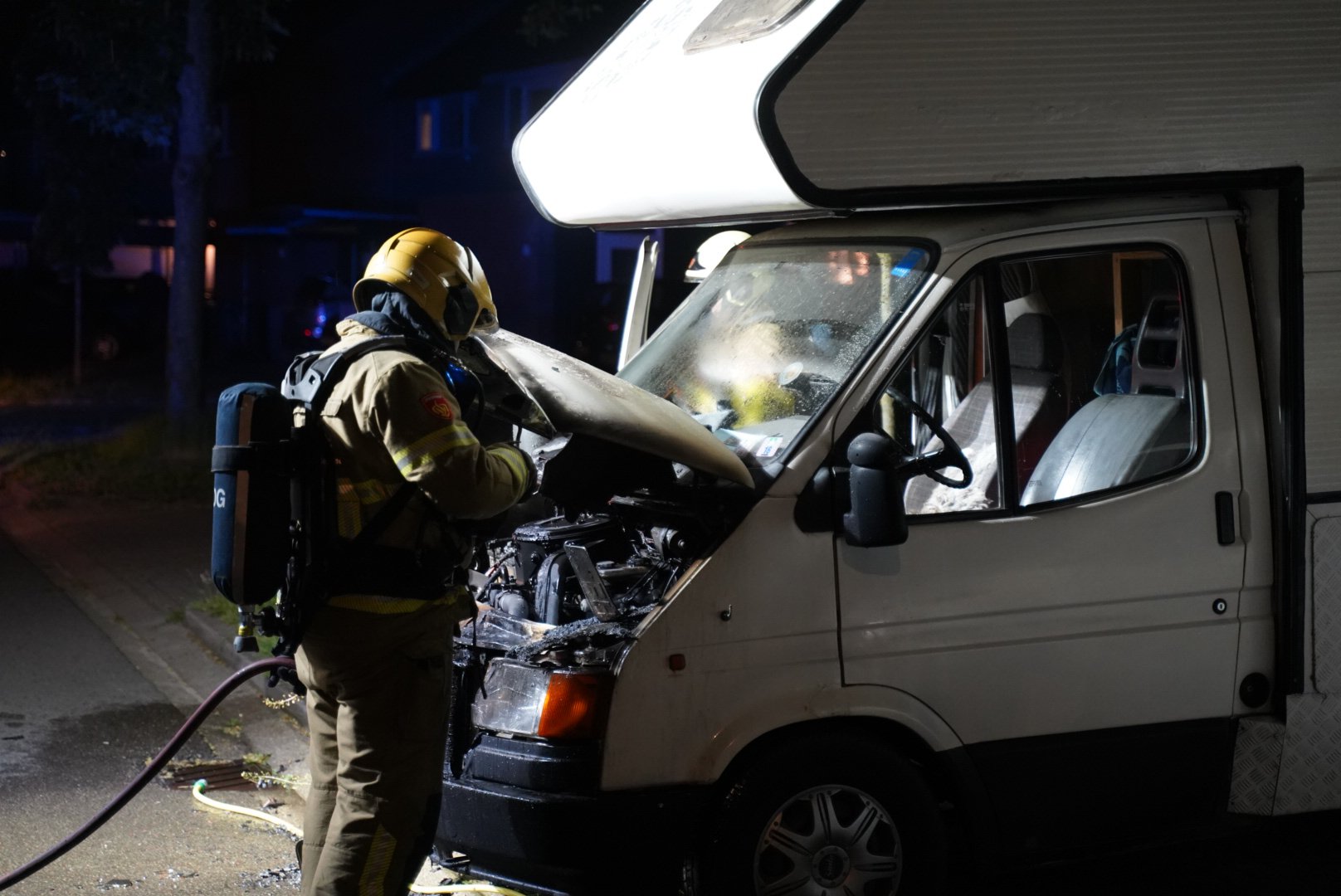 Buurtbewoner blust nachtelijke camperbrand in badjas met tuinslang