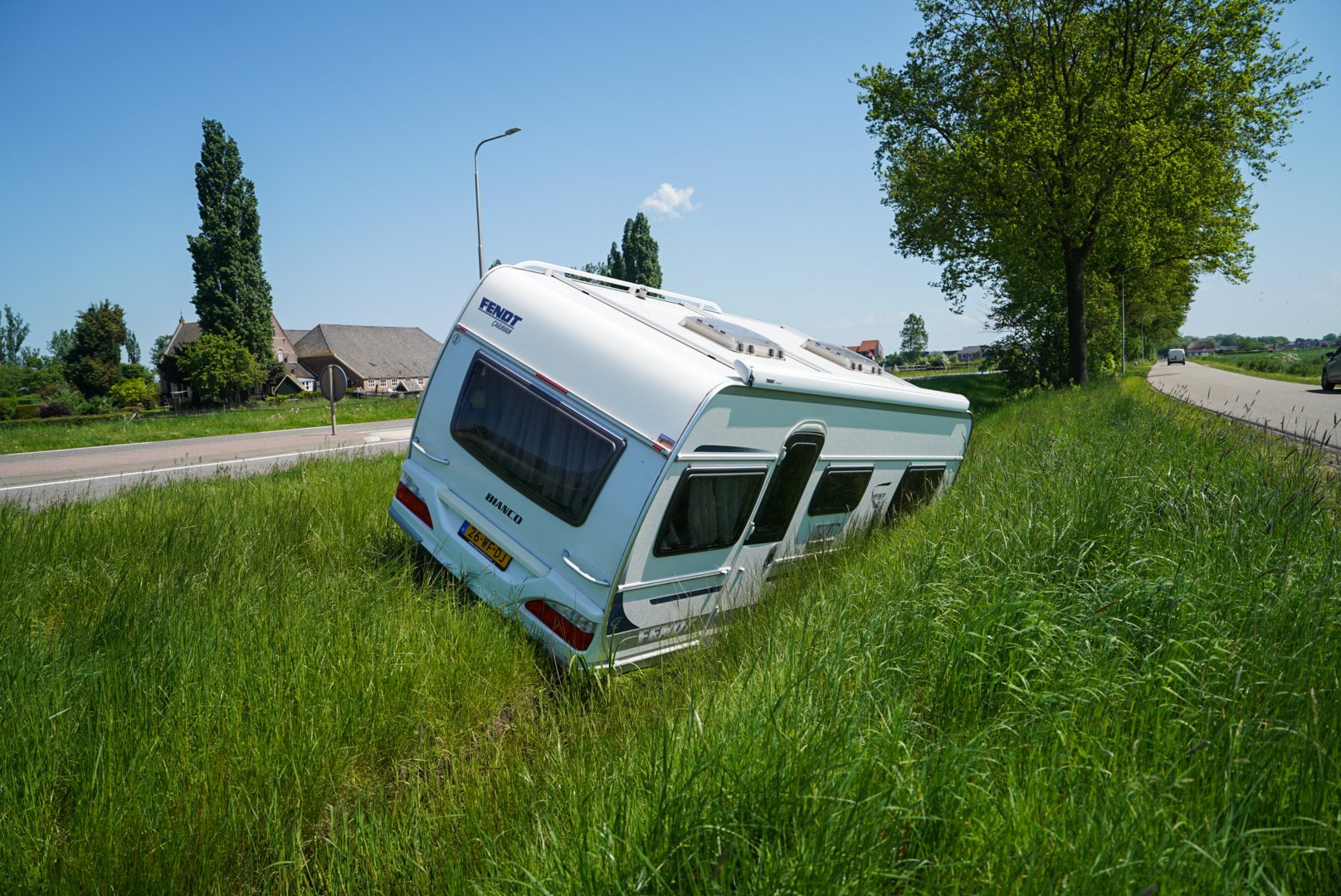 Caravan schiet los van auto en komt in slootje terecht