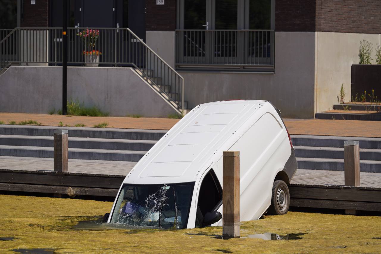 Pakketbezorger vergeet handrem, bestelbus belandt in sloot