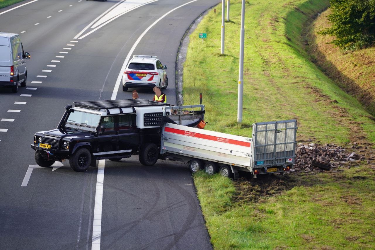 Auto met aanhanger schaart en verliest lading