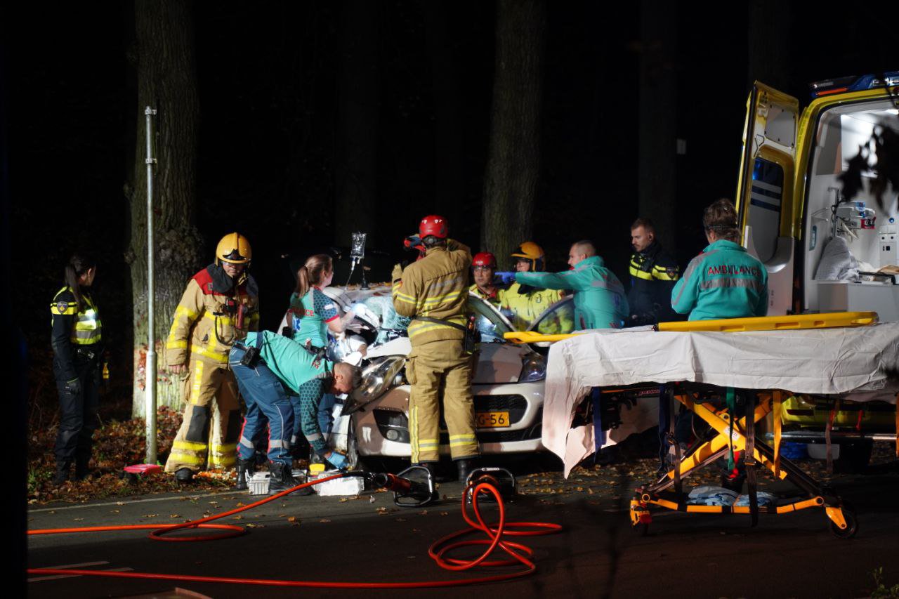 Automobilist bekneld na botsing tegen boom