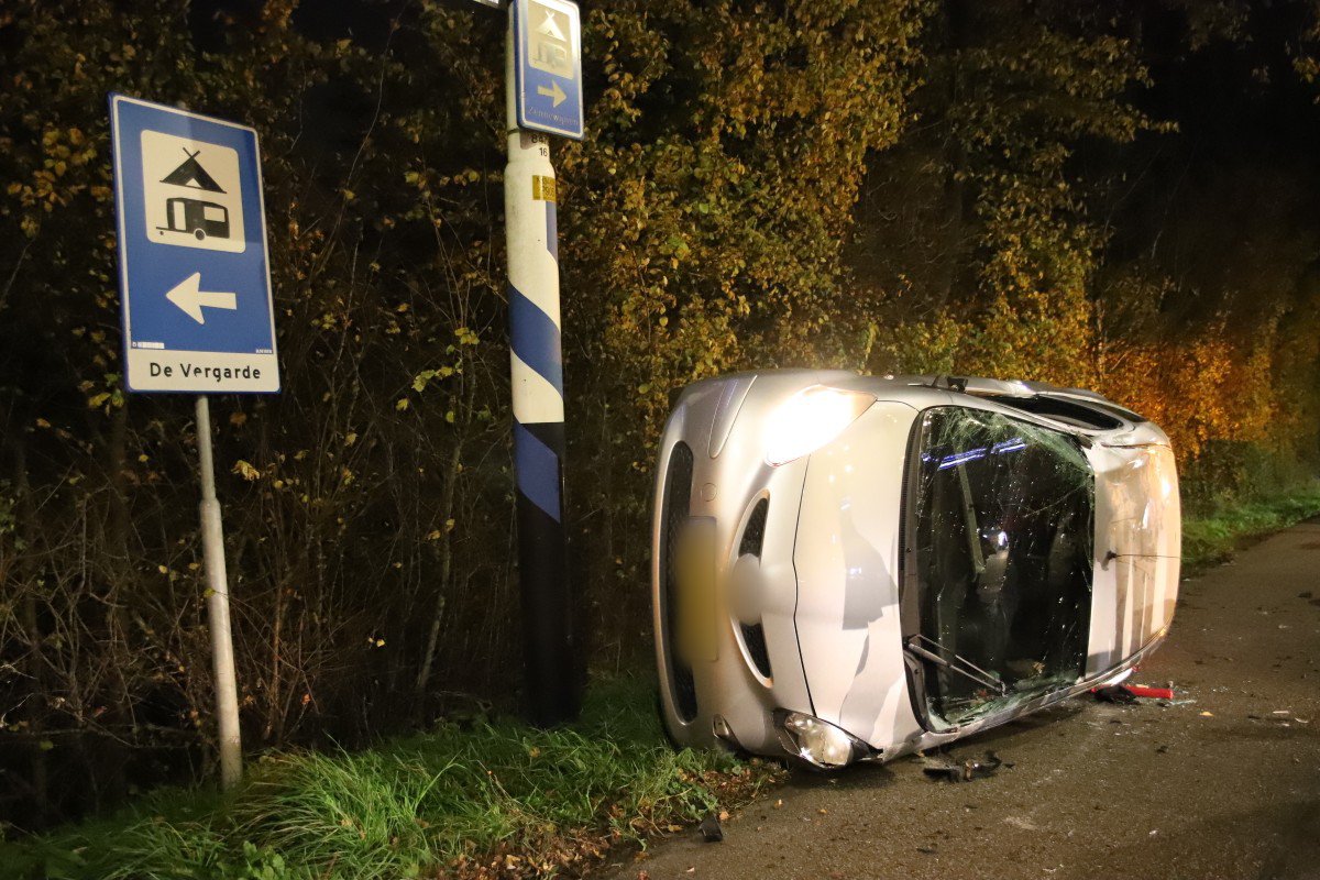 Vrouw ramt verkeerslicht en belandt met voertuig op zijkant