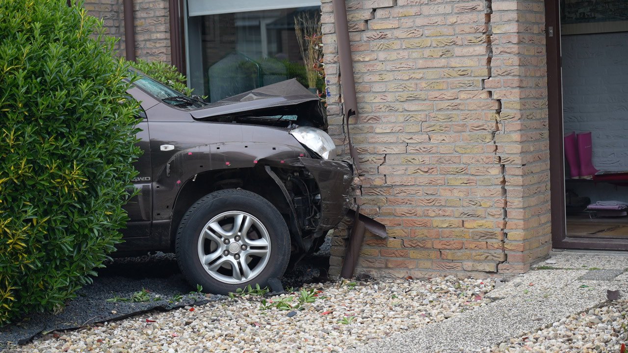 Auto ramt gevel van woning, bestuurder gewond