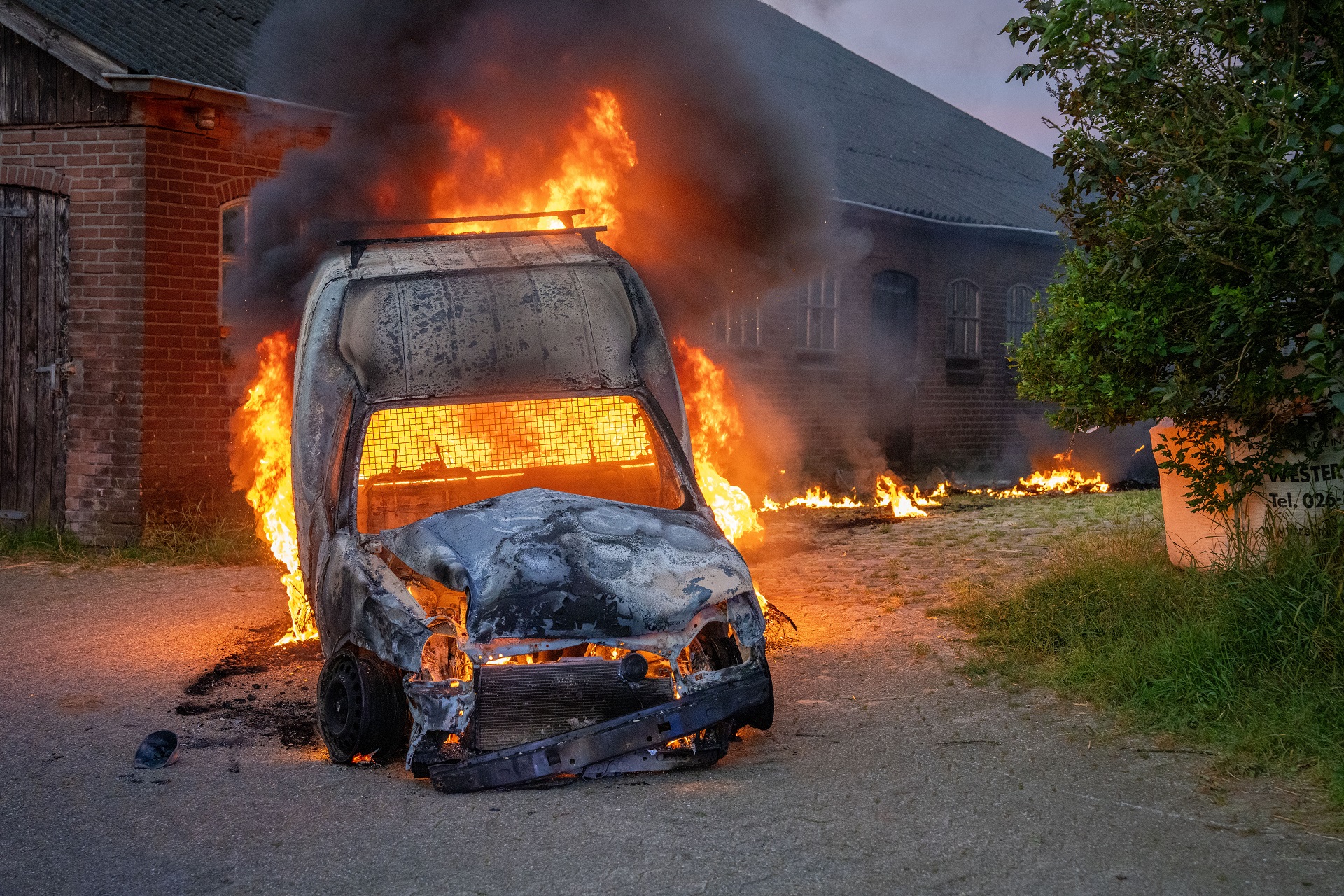 Mannen slaan alarm na ontdekken autobrand, bewoner trekt brandende auto met tractor weg