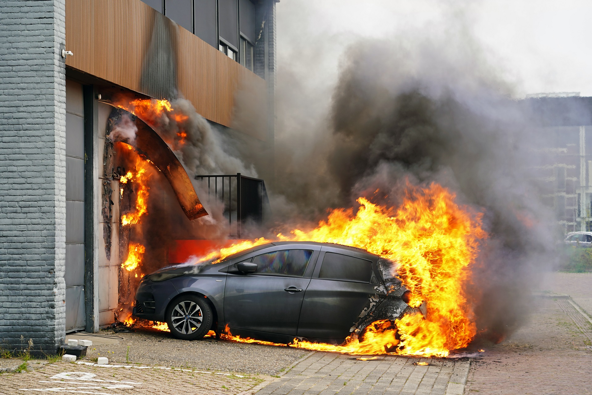 Elektrische auto vliegt in brand tijdens opladen, vlammen slaan over naar bedrijfspand