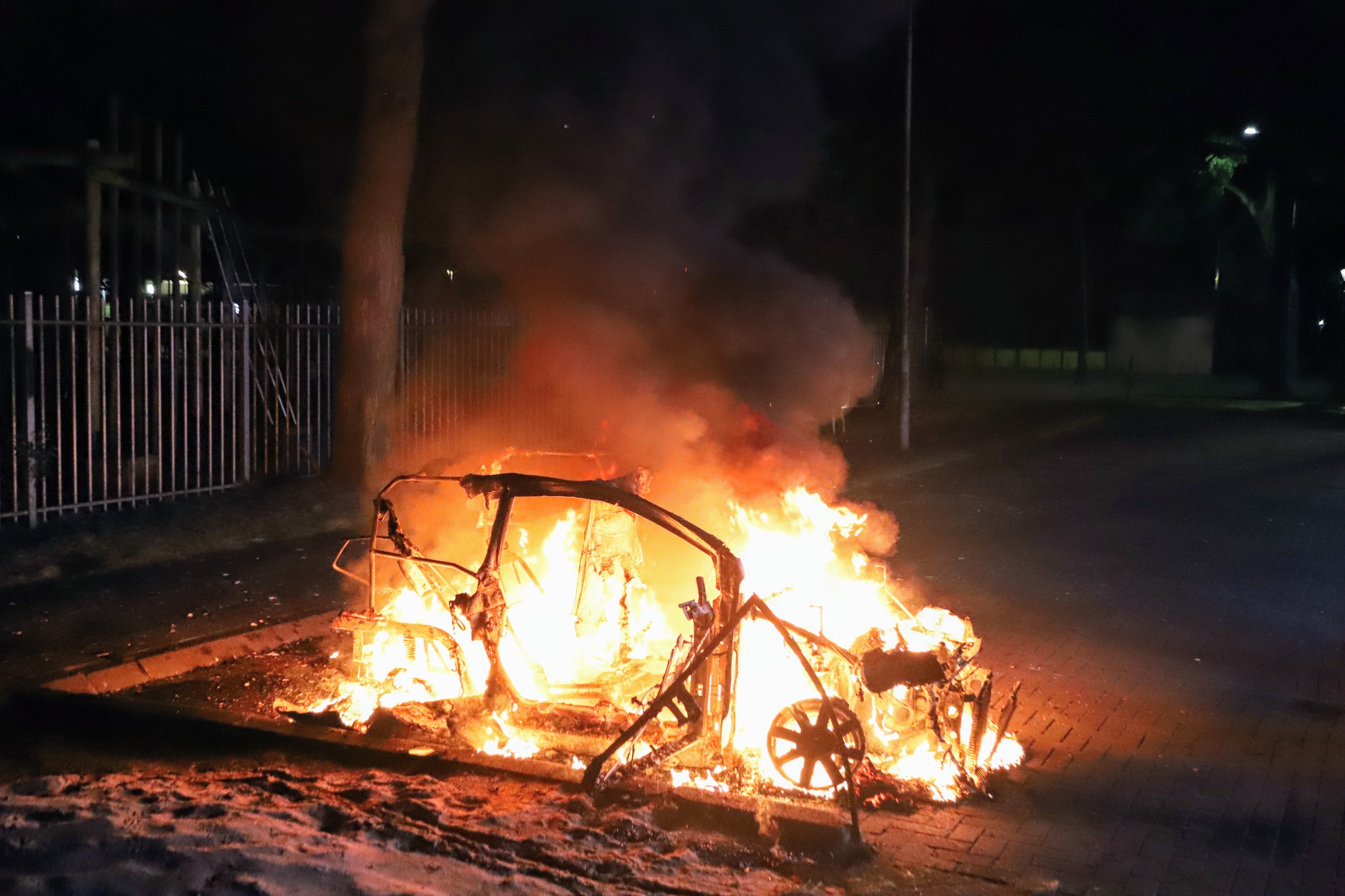 Voertuig in lichterlaaie achter sporthal, politie doet onderzoek