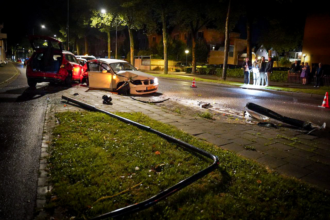 Twee gewonden na botsing tegen lantaarnpaal en geparkeerde auto’s