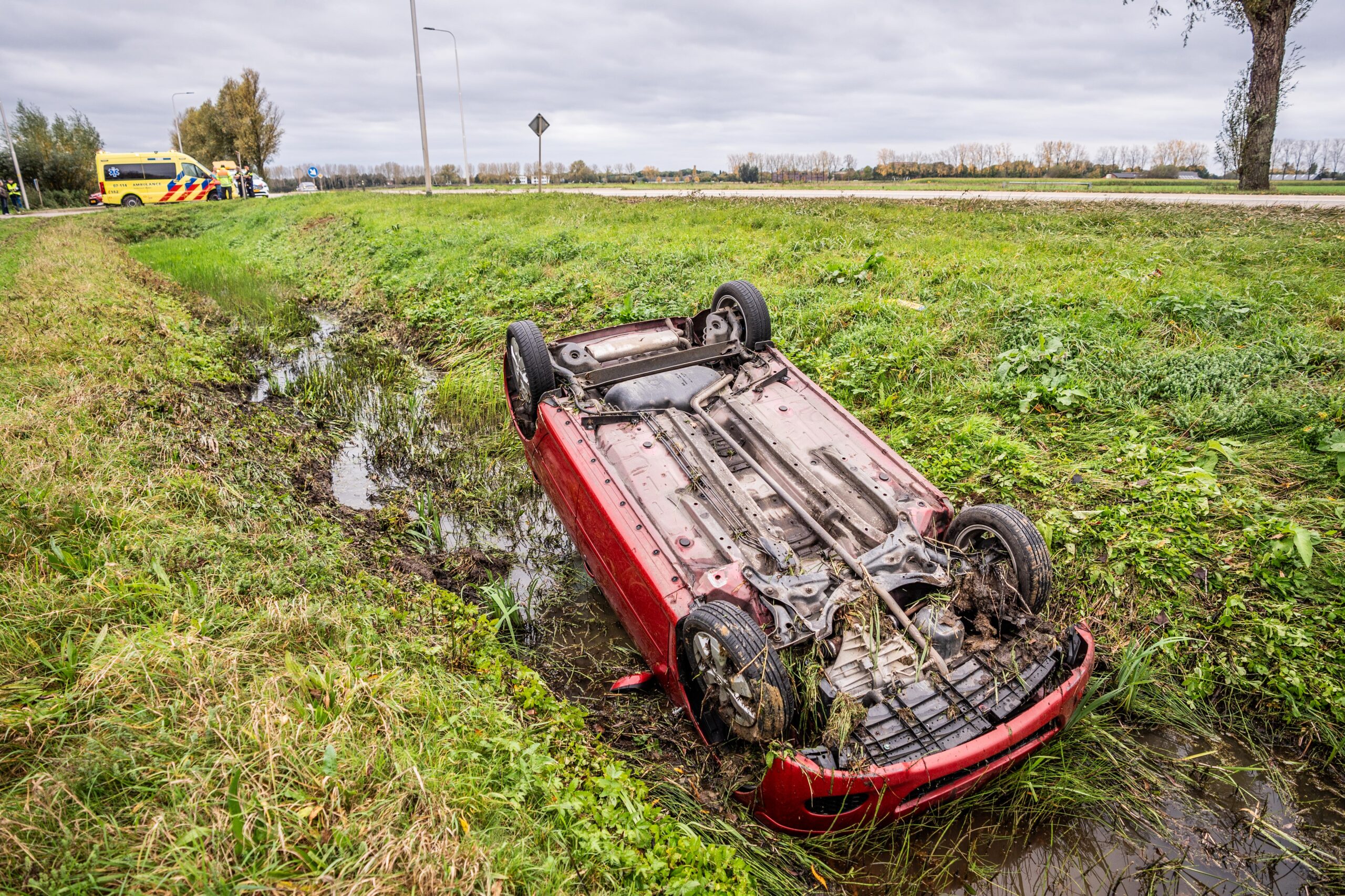 Automobilist schikt van ooievaar, auto op z’n kop in sloot