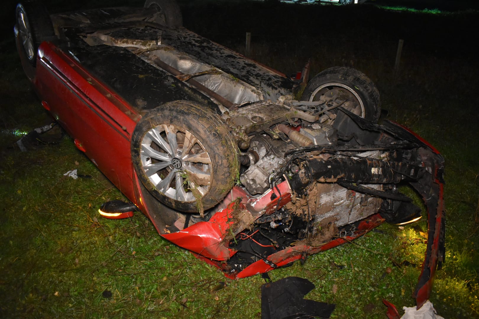 Auto raakt van dijk en belandt op dak in weiland