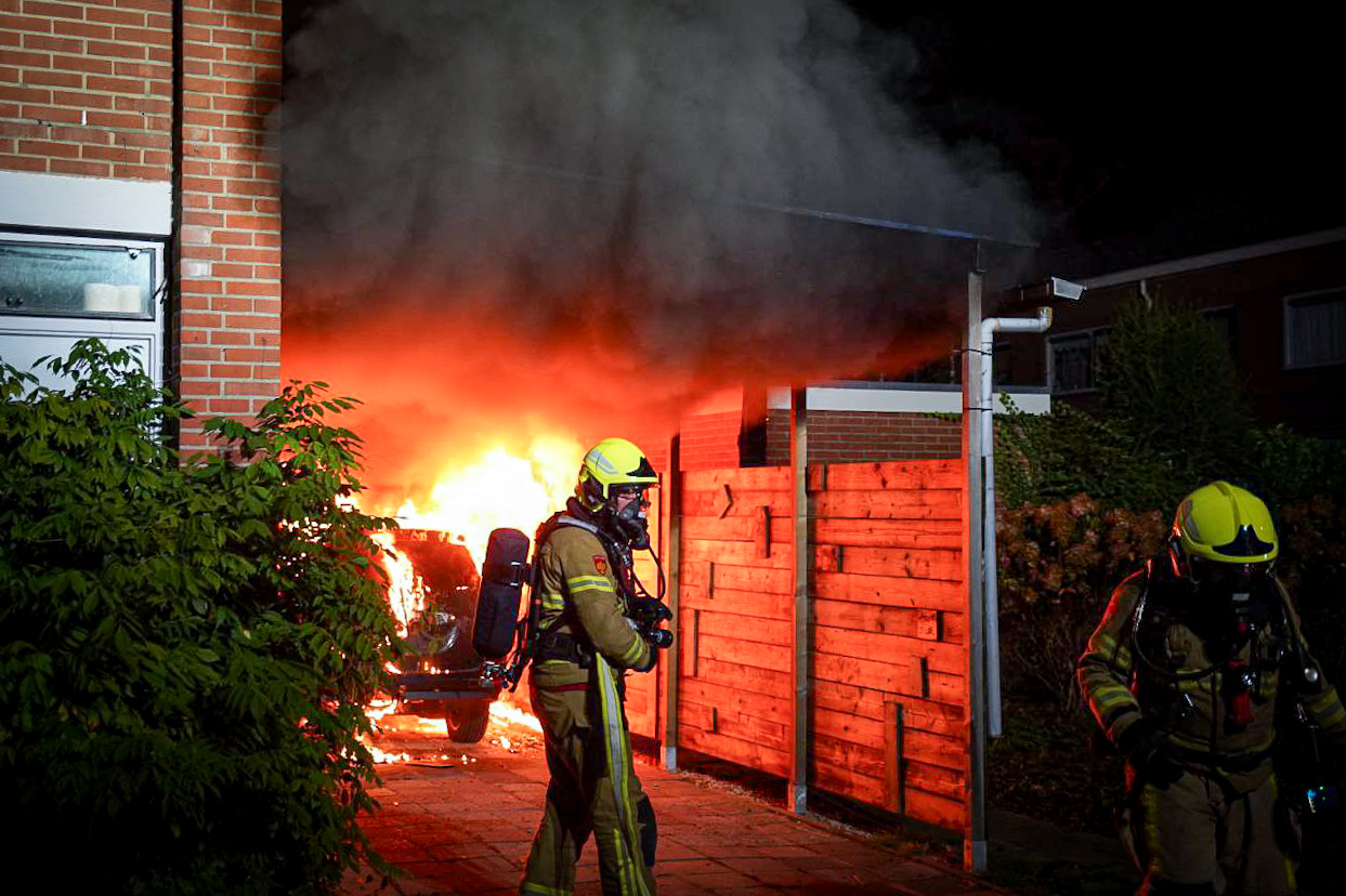 Auto vliegt in brand onder carport, brandweer voorkomt erger