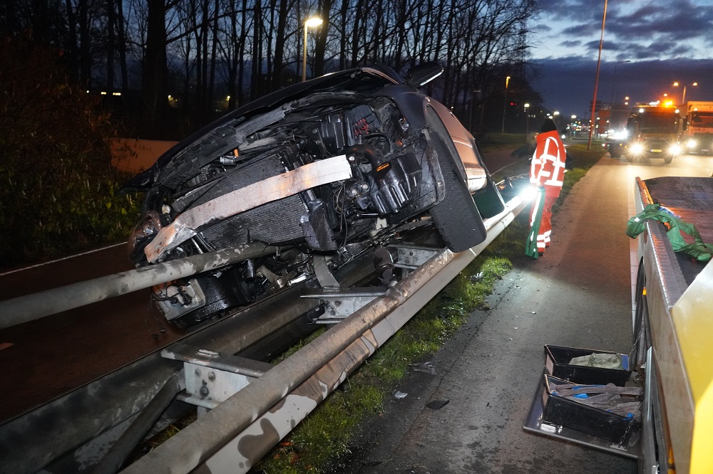 Automobilist wijkt uit en belandt bovenop vangrail