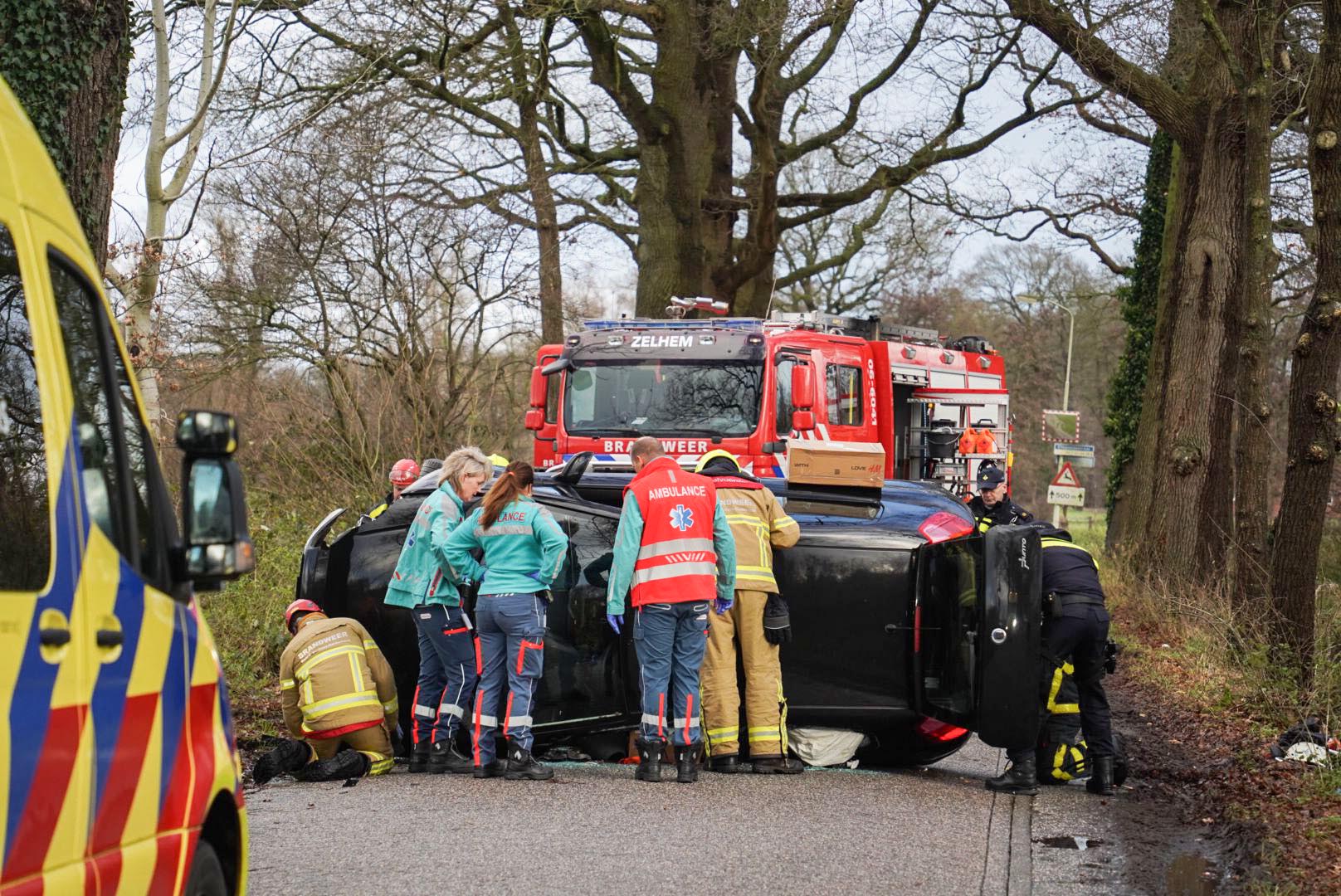 Auto op z’n kant na botsing tegen boom, vrouw gewond